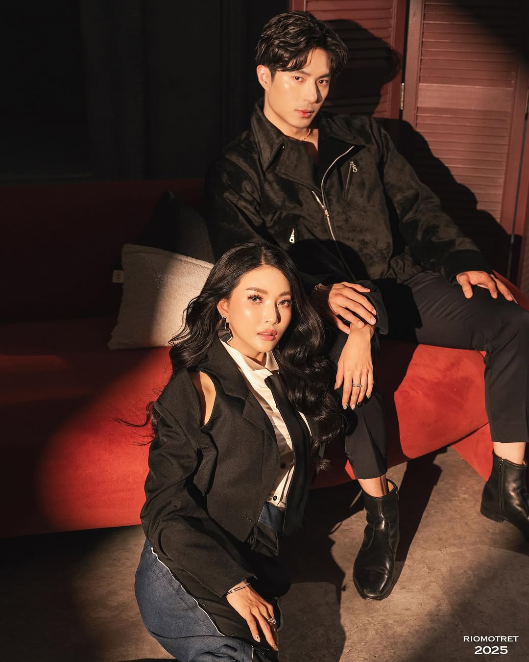 Komta campaign duo sitting on red sofa